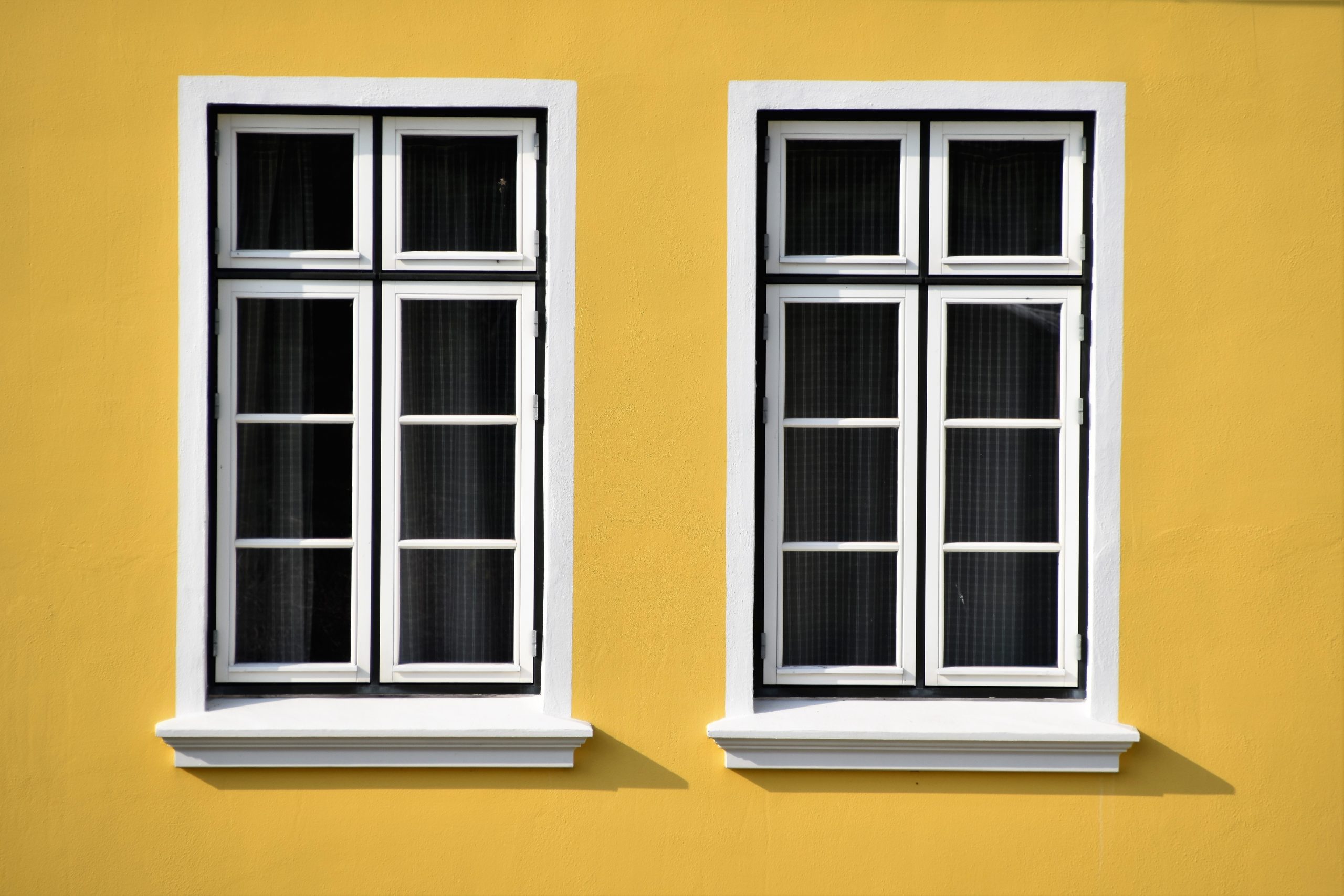 Mean Green Power Clean's Window Washing Services. Couple of windows on a yellow wall